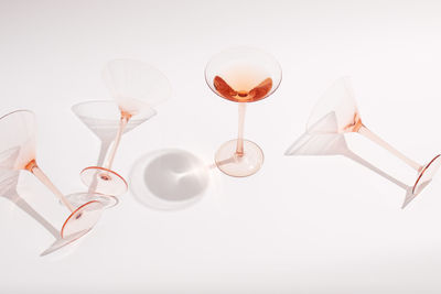 High angle view of wine glasses on table against white background