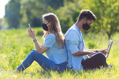 Young woman using mobile phone in field