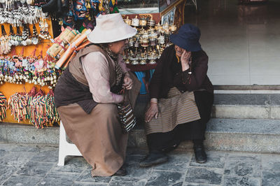 People sitting on street at market