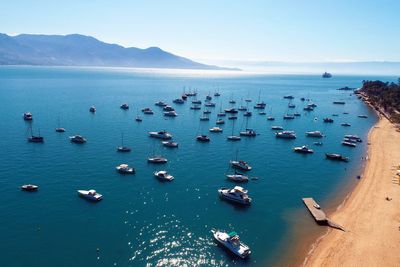 High angle view of sailboats moored in sea against sky