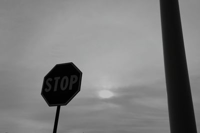 Low angle view of road sign against sky