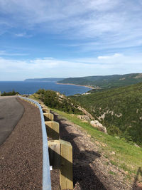 Scenic view of road by mountains against sky