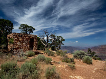 Abandoned built structure on landscape against sky