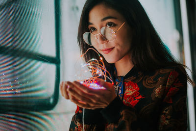 Portrait of a smiling young woman drinking glass