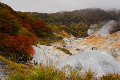 Scenic view of waterfall against sky during autumn