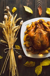 Autumn composition with leaves, ripe pumpkin and thanksgiving turkey on a dark wooden table.