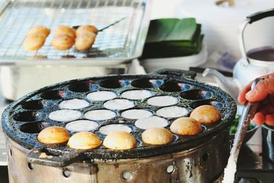 Cropped hand making fried food in cooking pan