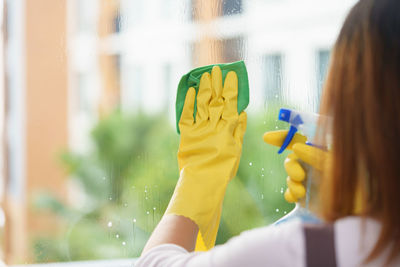 Midsection of woman cleaning glass window