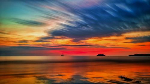 Scenic view of sea against dramatic sky during sunset