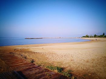 Scenic view of beach against clear blue sky