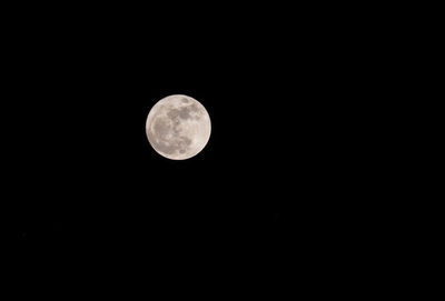 Low angle view of full moon against sky at night