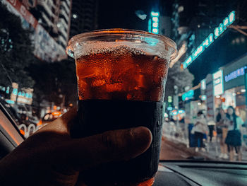 Close-up of hand holding beer glass