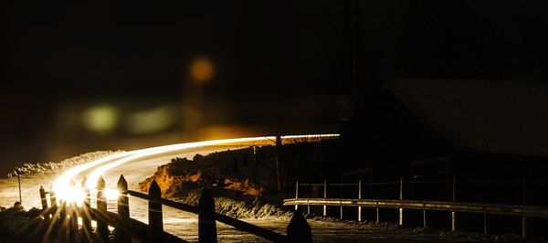 Illuminated bridge against sky at night