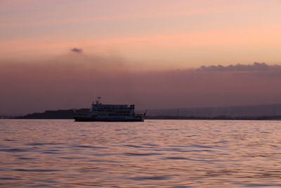 Ship sailing on sea against sky during sunset