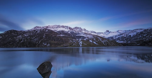Scenic view of lake and snowcapped mountains against sky