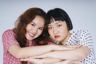 Portrait of lesbian couple against gray background