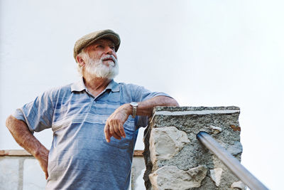 Portrait of a stylish older man wearing a beret on a white background