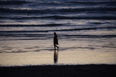 Silhouette man walking on beach