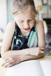 Girl reading book in classroom