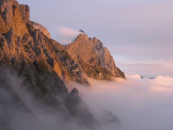 Rock formations in mountains against sky during sunset