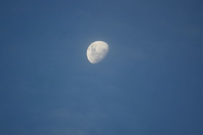 Low angle view of moon against clear blue sky