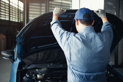 Rear view of man standing in car