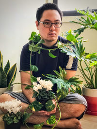 Portrait of young man with potted plants