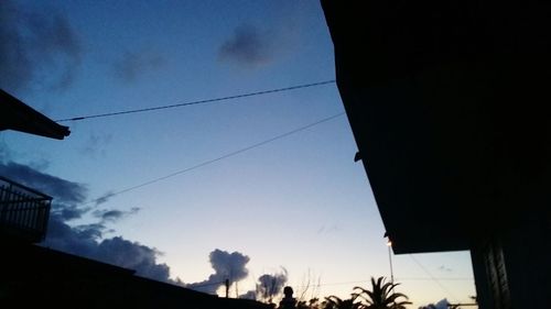 Low angle view of silhouette trees against blue sky