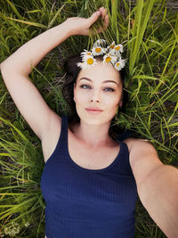 Portrait of beautiful young woman with flower petals on grass