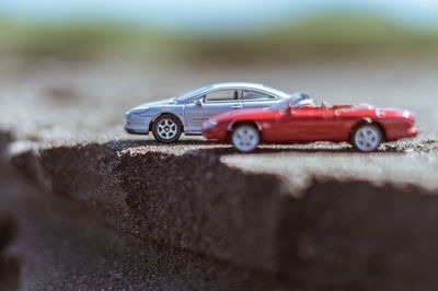 Close-up of red toy car on retaining wall