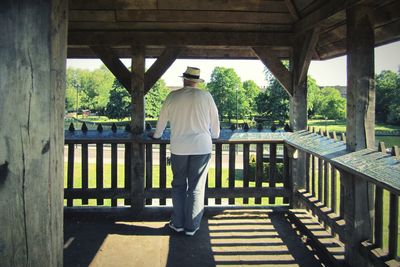 Rear view of man standing by railing