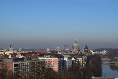 Illuminated buildings in city against clear sky