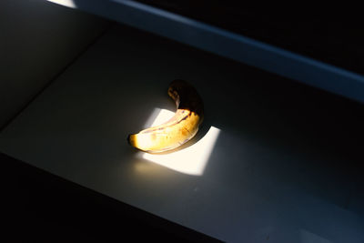 High angle view of lit candle in darkroom