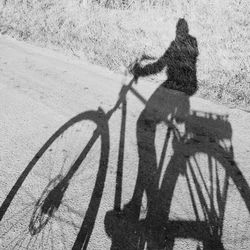 Shadow of person riding bicycle on road