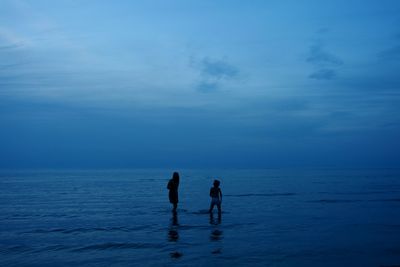 Men in sea against sky