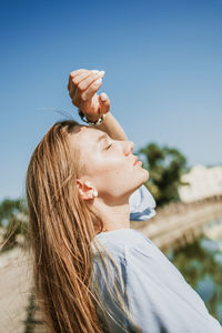 Side view of woman standing against sky