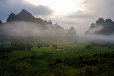 Scenic view of landscape against sky during foggy weather