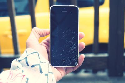 Cropped hand of person holding mobile phone