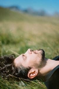 Portrait of young woman lying on field