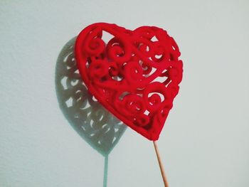 Close-up of red heart shape over white background