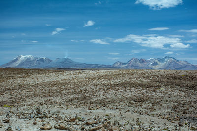 Scenic view of snow covered mountains against blue sky