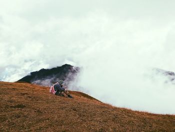 Man standing on mountain against sky