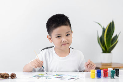 Portrait of cute boy holding ice cream on table