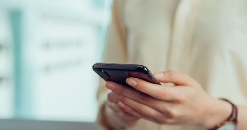 Midsection of man using mobile phone