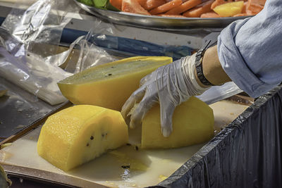 Close-up of person preparing food at market stall