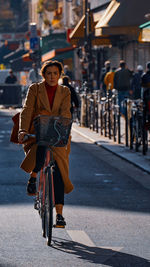 Portrait of woman riding bicycle on road in city