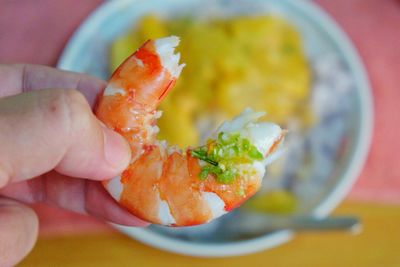 Cropped image of person holding prawn