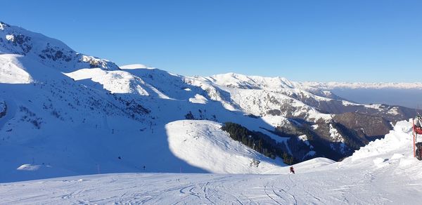 Scenic view of snowcapped mountains against clear sky