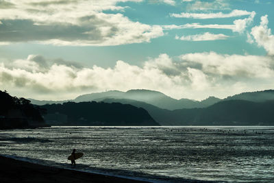 Silhouette person on beach against sky