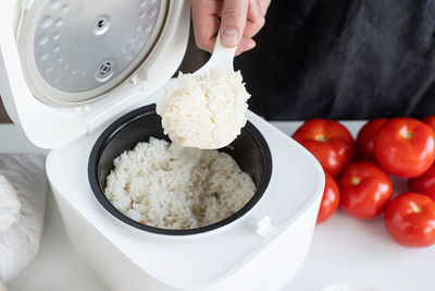 Kitchen appliances and devices. electric smart rice cooker on wooden counter-top in the kitchen
